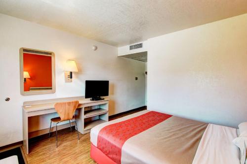 a hotel room with a bed and a desk with a computer at Motel 6-Denver, CO - Airport in Denver