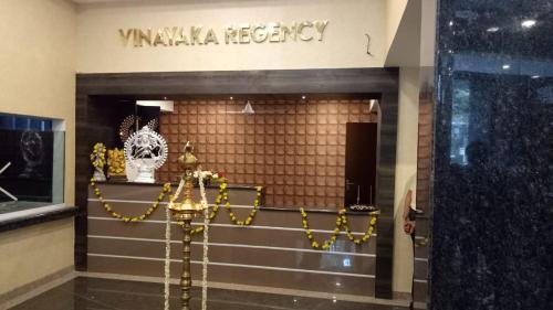 a lobby with a valkyrie mercy sign on the wall at Vinayaka Regency in Trivandrum