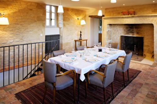 a dining room with a table and chairs and a fireplace at Les Hauts de Saint Vincent B&B proche Sarlat in Saint-Vincent-de-Cosse