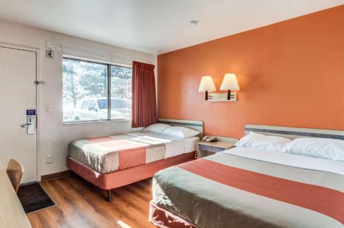 a hotel room with two beds and a window at Motel 6 Fort Collins, CO in Fort Collins