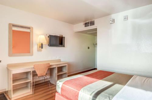 a room with a bed and a desk and a television at Motel 6 Fort Collins, CO in Fort Collins