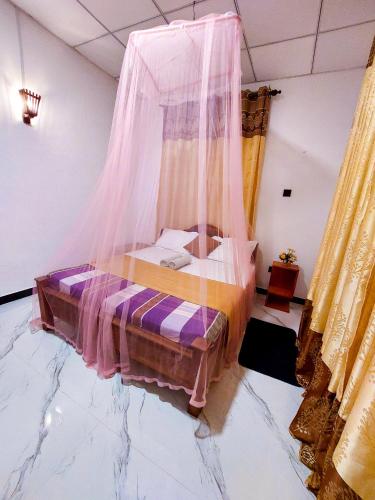 a bedroom with a bed covered in mosquito nets at Samuu Homestay Mirissa in Mirissa