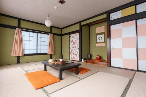 een woonkamer met een tafel en een paar groene muren bij 富士吉田たまきや in Fujiyoshida