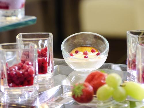 a table with a bowl of fruit and a plate of berries at Mercure Hotel Hamm in Hamm