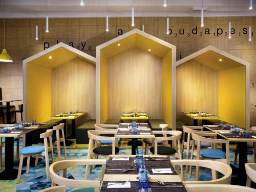 een eetkamer met tafels en stoelen in een restaurant bij Ibis Styles Budapest Center in Boedapest