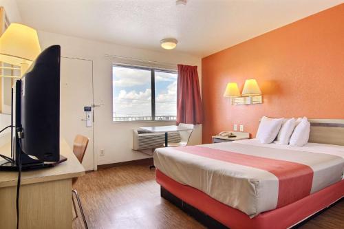 a hotel room with a bed and a flat screen tv at Motel 6-Fort Stockton, TX in Fort Stockton
