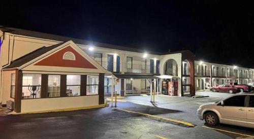 un parcheggio di notte di fronte a un edificio di Scottish Inns Augusta ad Augusta