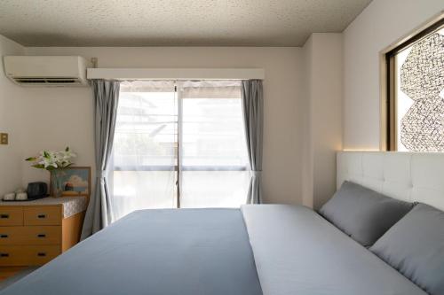 a bedroom with a bed and a large window at Peace 平和屋 in Osaka