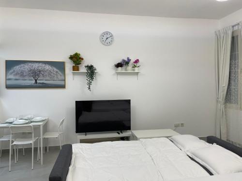 a bedroom with a bed and a table and a television at Studio in International City, Newly renovated with balcony! in Dubai