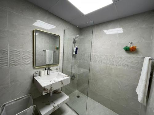 a bathroom with a sink and a shower with a mirror at Studio in International City, Newly renovated with balcony! in Dubai