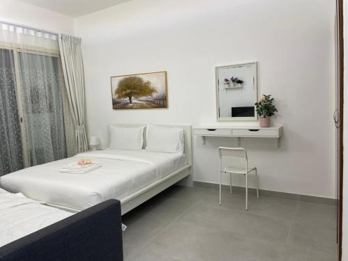 a room with two beds and a desk and a mirror at Studio in International City, Newly renovated with balcony! in Dubai