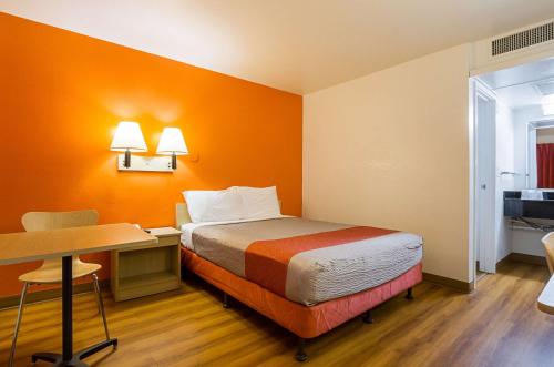 a small room with a bed and a desk and a desk at Motel 6 Mesa North in Mesa