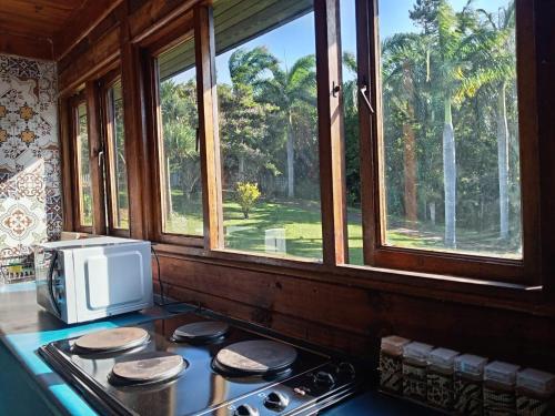 een keuken met een fornuis met magnetron en een raam bij Jungle Cabin Leisure Bay in Port Edward