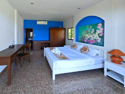 - une chambre avec un lit blanc, un bureau et une table dans l'établissement The Moon Rabbit Resort Pai, à Pai