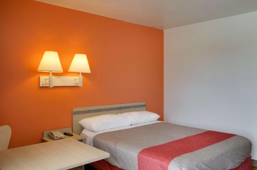 a small room with a bed and a table at Motel 6 Gulfport, MS Airport in Gulfport