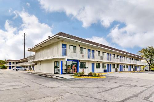a large white building with blue windows and a parking lot at Motel 6-Pittsburgh, PA - Crafton in Pittsburgh