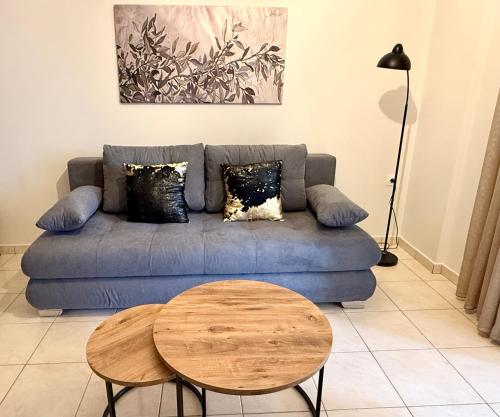 een woonkamer met een blauwe bank en een tafel bij Domus Philippi & parking in Larisa