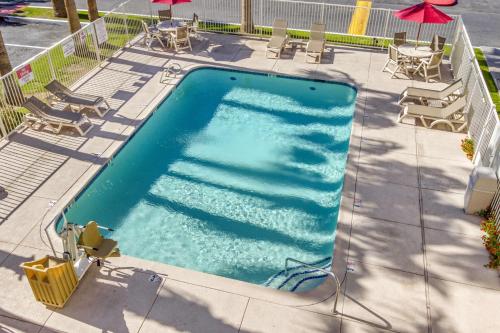 an overhead view of a swimming pool with chairs and umbrellas at Motel 6-Phoenix, AZ - West in Phoenix