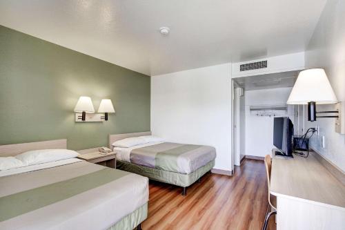 a hotel room with two beds and a television at Econo Lodge Midvale in Midvale