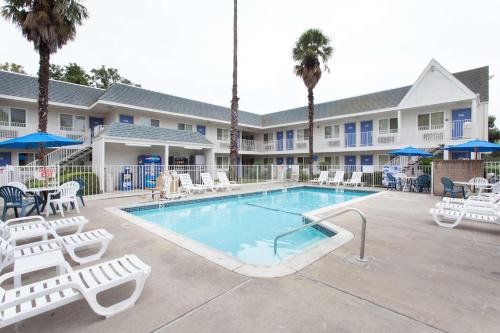a swimming pool with lounge chairs and a resort at Motel 6-Sacramento, CA - Central in Sacramento