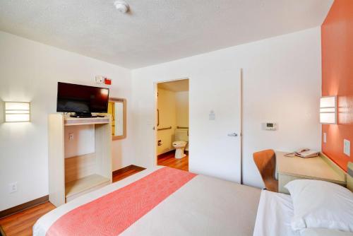 a hotel room with a bed and a flat screen tv at Motel 6-Southington, CT - Hartford in Southington
