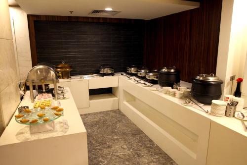 a kitchen with a counter with aasteryasteryasteryasteryasteryasteryasteryasteryastery at Lords Plaza Surat in Surat