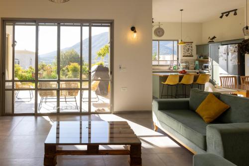 un soggiorno con un divano e un tavolo di Our Mount Meron Orchard - your perfect getaway a Tsiv'on