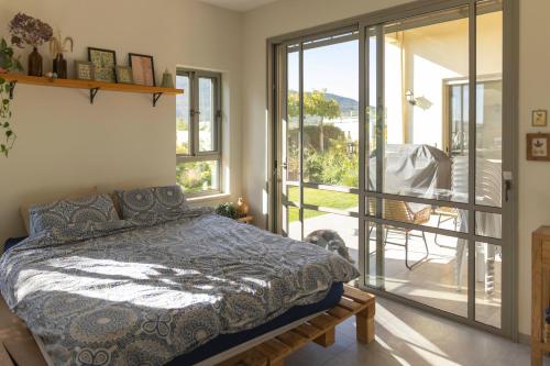 una camera da letto con un letto e un balcone di Our Mount Meron Orchard - your perfect getaway a Tsiv'on