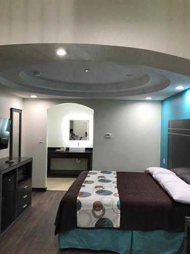 um quarto com uma cama e uma televisão em Americas Best Value Inn & Suites Spring / N. Houston em Spring