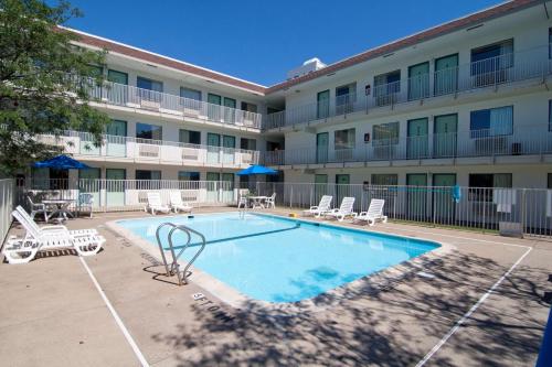 a large apartment building with a swimming pool and lounge chairs at Motel 6-Roseville, MN - Minneapolis North in Roseville