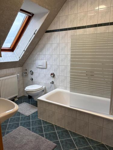 a bathroom with a bath tub and a toilet at Ferienwohnung Aischgrund 75qm Nähe Nürnberg Bamberg Steigerwald in Lonnerstadt
