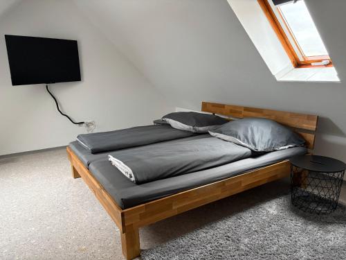 a bedroom with a wooden bed with a television on the wall at Ferienwohnung Aischgrund 75qm Nähe Nürnberg Bamberg Steigerwald in Lonnerstadt