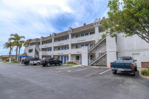 a large white building with cars parked in a parking lot at Motel 6-Chula Vista, CA - San Diego in Chula Vista