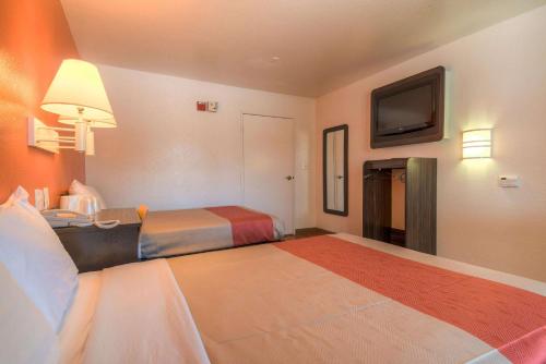 a hotel room with two beds and a flat screen tv at Motel 6-Chula Vista, CA - San Diego in Chula Vista