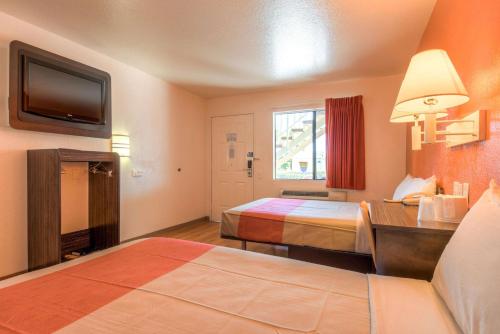 a hotel room with two beds and a television at Motel 6-Chula Vista, CA - San Diego in Chula Vista