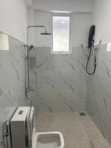 a bathroom with a shower and a toilet and a phone at Why Not Guset House Ella in Ella