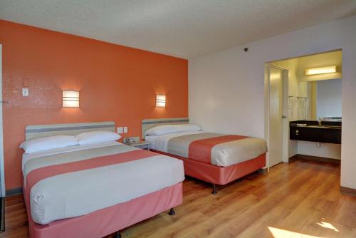 a hotel room with two beds and a bathroom at Motel 6-Wethersfield, CT - Hartford in Wethersfield