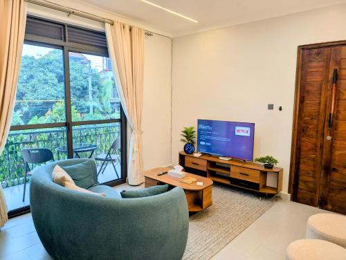 un salon avec une grande fenêtre et une télévision dans l'établissement Hakuna Matata Apartment in Munyonyo, à Kampala