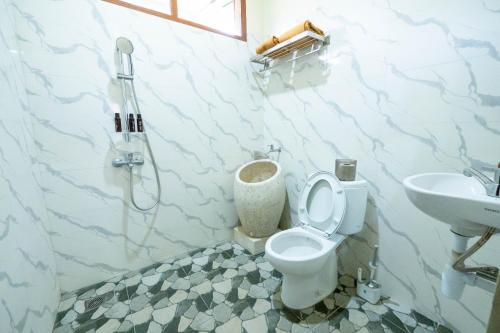 een badkamer met toilet en wastafel bij G Beach Hotel in Grajagan