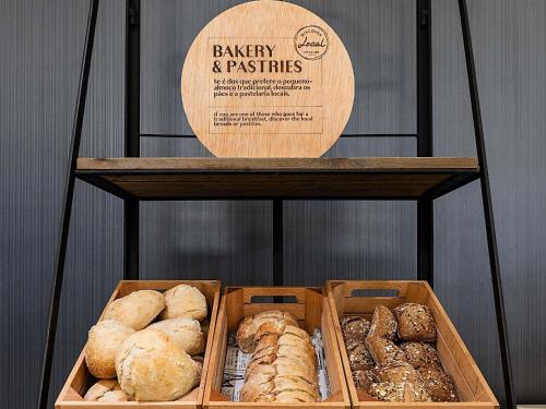 twee manden met verschillende soorten brood op een plank bij Hotel Mercure Lisboa in Lissabon