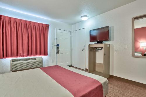 a hotel room with a bed and a tv at Motel 6-Flagstaff, AZ - West - Woodland Village in Flagstaff