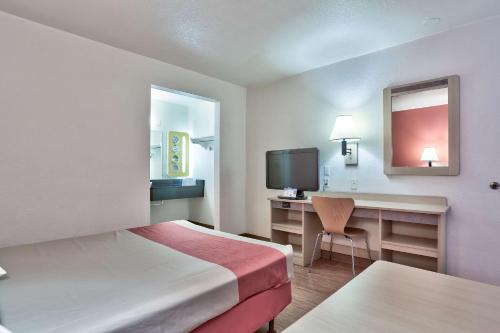 a hotel room with a bed and a desk and a television at Motel 6-Flagstaff, AZ - West - Woodland Village in Flagstaff