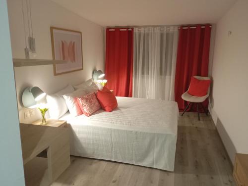 ein Schlafzimmer mit einem großen Bett mit roten Vorhängen in der Unterkunft L'Etage 1 2 in Pointe-à-Pitre