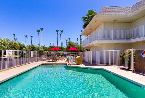 a swimming pool in front of a house at Motel 6-Mesa, AZ - South in Mesa