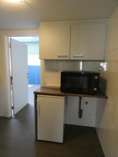 a kitchen with a microwave on top of a counter at Gastenverblijf Op den dreef in Hamont
