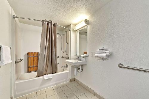 a white bathroom with a sink and a shower at Motel 6-Glenview, IL - Chicago North in Glenview