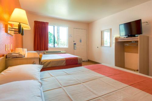 a hotel room with two beds and a flat screen tv at Motel 6-El Cajon, CA - San Diego in El Cajon