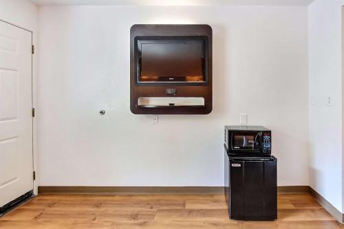 a flat screen tv on a wall with a microwave at Motel 6-Sunnyvale, CA - North in Sunnyvale