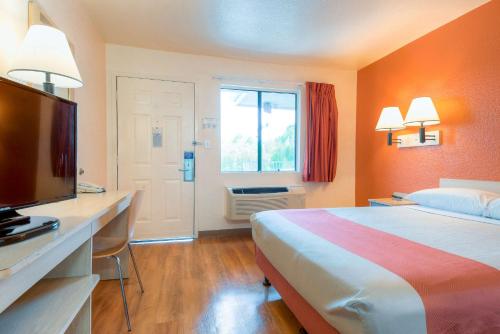 a hotel room with a bed and a flat screen tv at Motel 6-El Cajon, CA - San Diego in El Cajon