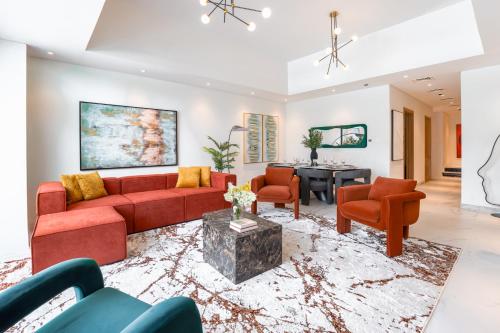 a living room with a red couch and chairs at Private Pool Paradise Villa! Dubai Mall in a Flash! Complimentary Full Mid-Stay Refresh for 1 week stay in Dubai